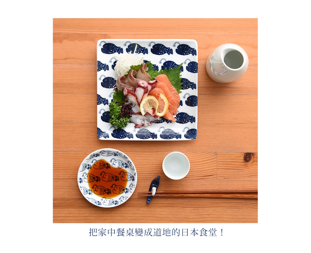 cocomarine × Janke 方形餐盤，以白色陶瓷為底，印有深藍色線條勾勒的可愛魚形圖案。盤中盛有鮭魚生魚片、章魚、蘿蔔絲等日式料理，搭配醬油碟、小瓷杯與一雙筷子，整體呈現日式餐桌的氛圍。