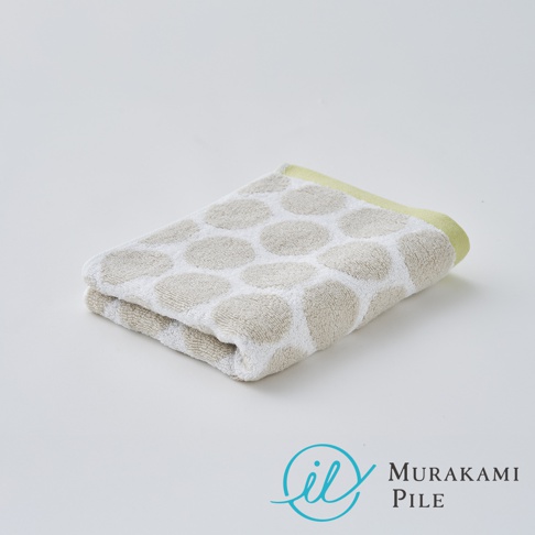 Murakami Pile 品牌標誌和名稱，旁邊放著一條摺疊的淺米色毛巾，上面印有淺米色圓點圖案，邊緣是淺綠色。