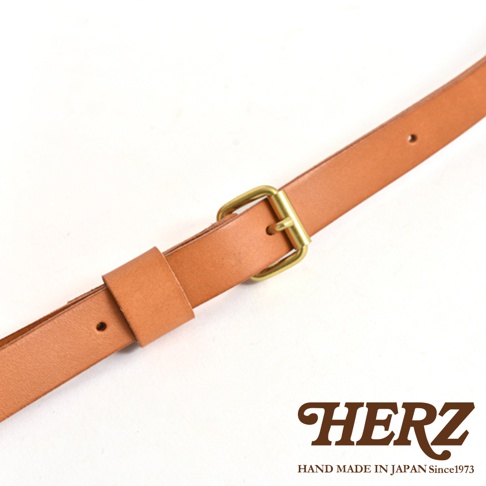 職人手作皮革迷你托特包 T-11 的肩帶細節，由淺棕色皮革製成，配有黃銅色金屬釦環，可調節長度。