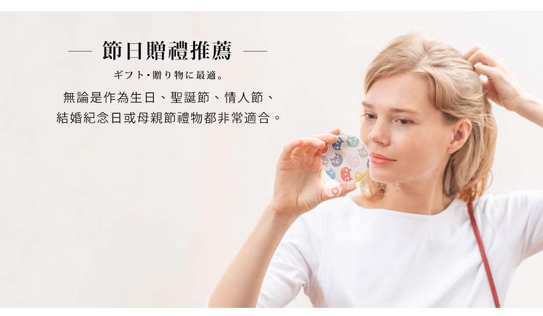 女性手持一個圓形隨身小鏡，鏡面印有彩色卡通貓咪圖案，鏡框為白色。
