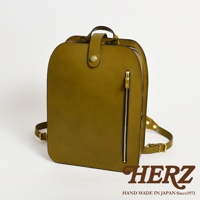 職人手作皮革商務休閒兩用後背包 R-36，橄欖綠色，採用真皮材質，設計簡約，前有拉鍊口袋，頂部有提把及金屬釦設計，可肩背或後背。