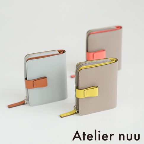 三個 Atelier nuu 品牌的 noble 皮革 L 型拉鍊雙折短夾放置於白色背景，分別呈現淺灰配橘色、灰褐色配黃色以及灰褐色配橘色的撞色設計，皆具備簡約皮革質感與精緻的拉鍊細節。