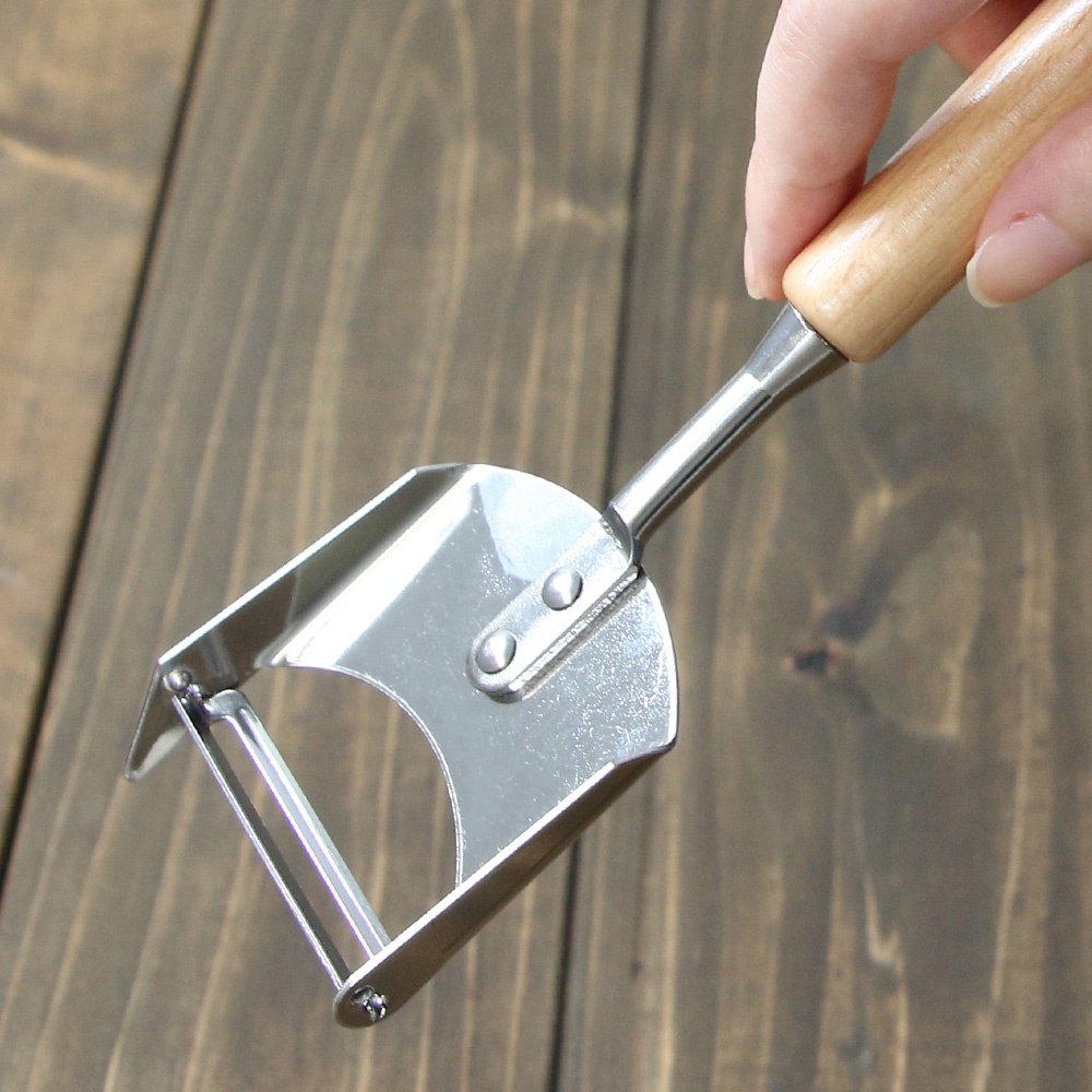 VEGET 不鏽鋼木柄削皮刀，擁有銀色不鏽鋼刀刃和刀頭，搭配圓潤的淺木色木質手柄，整體呈銀色與木色。