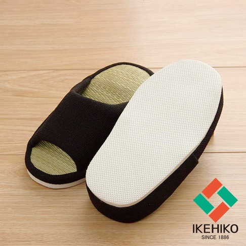 一雙黑色藺草室內拖鞋，鞋面為編織材質，鞋墊為藺草編織，鞋底為白色防滑紋路。