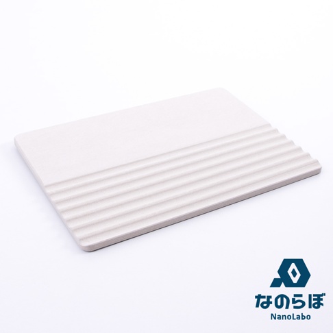 淺灰色珪藻土製成的置物墊，表面有規則的條狀紋路，角落圓潤。