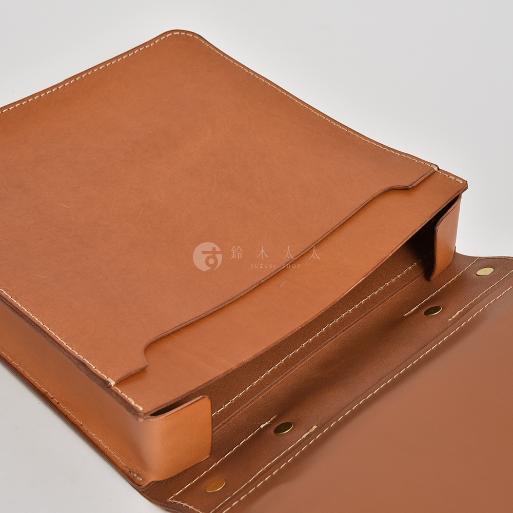 職人手作皮革三口袋三用後背包，展示棕色皮革材質，車縫線清晰，設計簡潔，可見背包側邊與內部結構。