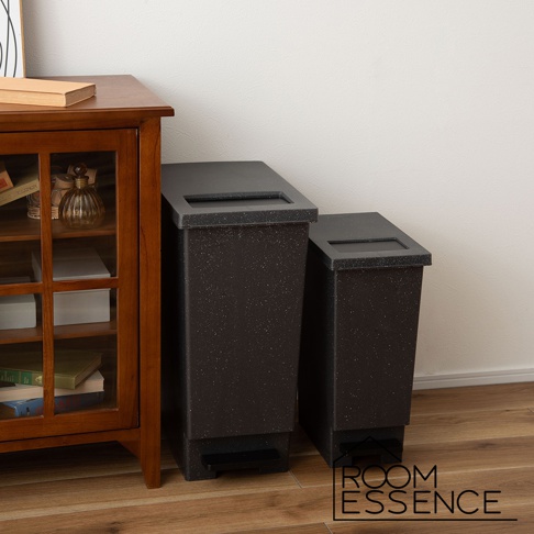 兩個黑色附蓋簡約垃圾桶，帶有腳踏板，表面有細小白色斑點，其中一個較高，另一個較矮，擺放在木質地板旁。
