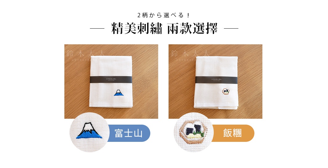 白色八重紗擦拭巾，左款繡有藍色富士山圖案，右款繡有牛和米飯圖案，皆以深色紙帶束起。