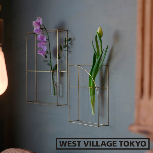 兩個黃銅金屬線製成的方形掛壁花器，其中一個花器插有紫色花束，另一個花器插有綠色花苞，均置於玻璃試管中。