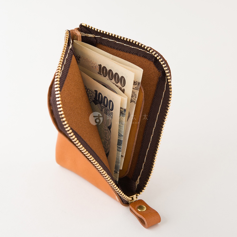 這款日本HERZ手工製作的皮革迷你錢包呈現棕色質感，採L型拉鍊設計，內部設有夾層並展示著日圓紙鈔，整體外觀簡潔輕巧，適合收納隨身零錢與紙鈔。