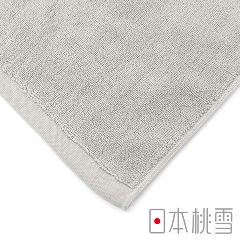 淺灰色紋理浴墊，材質為柔軟的毛圈織物，邊緣有細緻的縫邊。