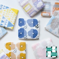 多款七層紗拭巾，印有藍色、黃色、粉色、紫色、橘色和灰色花朵與幾何圖案。