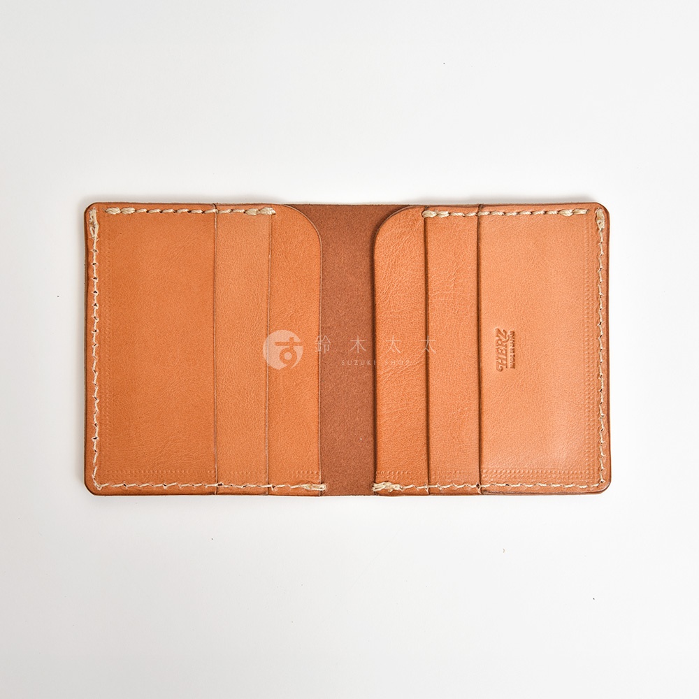日本HERZ職人手作皮革二折式薄型卡片鈔票夾，深棕色皮革內裡搭配淺棕色外層，內有數個卡槽，並壓印品牌Logo與產地資訊。