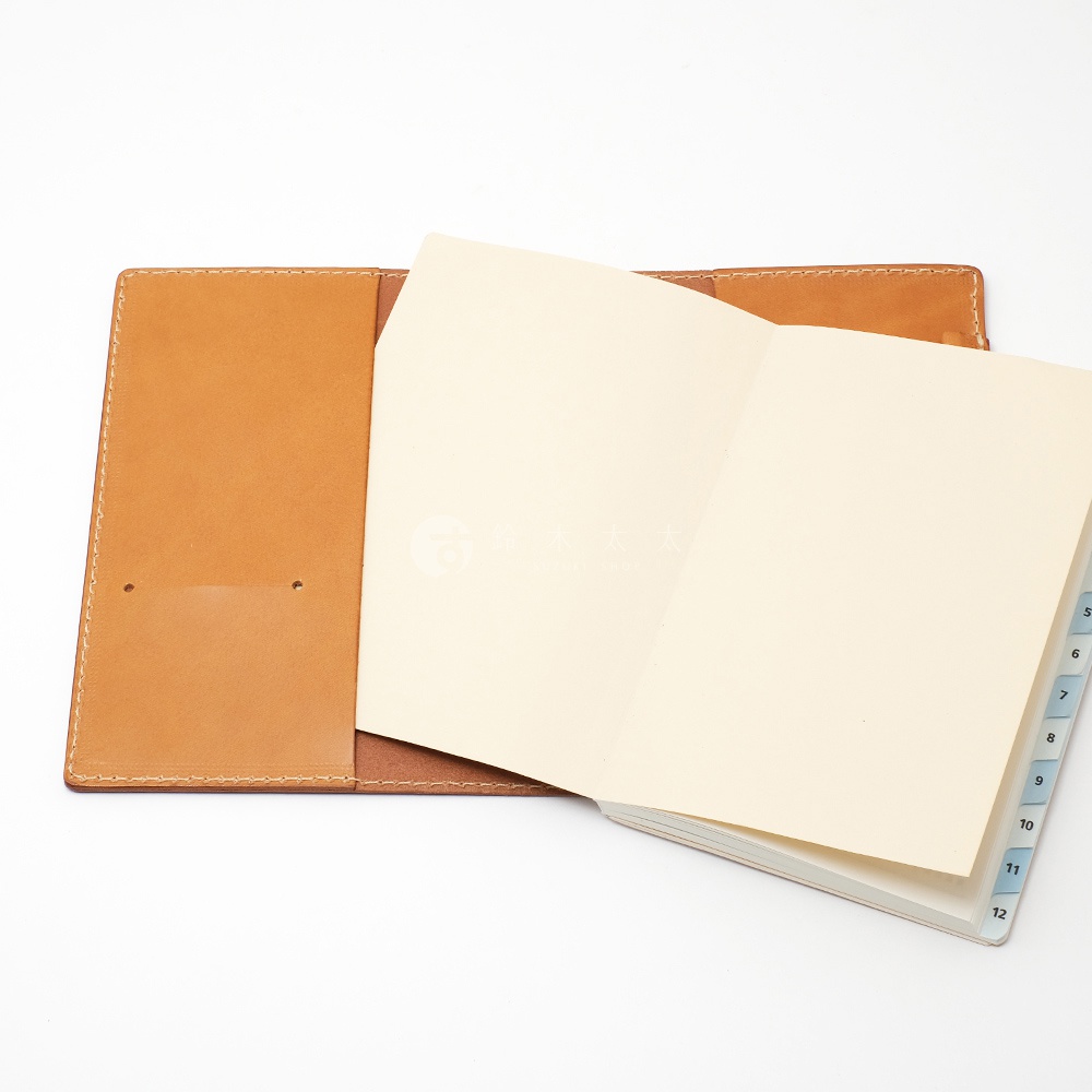 職人手作皮革B6記事本書套，淺棕色皮革，內含淺黃色紙張的記事本，側邊有標示數字的分類索引。