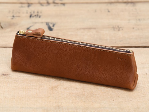 職人手作皮革Organ三角收納筆袋，M尺寸，採用棕色皮革材質，搭配金色拉鍊與同色皮革拉頭，簡約的設計與天然皮革紋理。