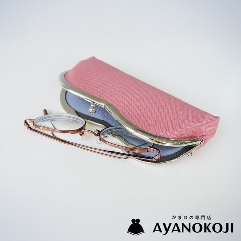京都職人手作 AYANOKOJI 品牌粉紅色編織紋路口金眼鏡盒，內襯藍色絨布，露出部分復古銅色細框眼鏡