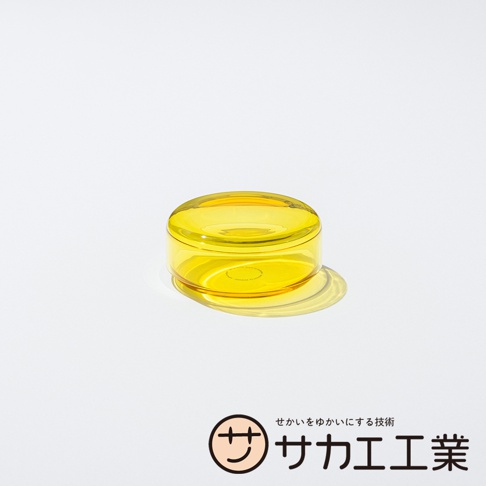 SAKAE 品牌標誌和日文文字，以及一個黃色的玻璃點心碗，帶有蓋子，碗呈圓形，在白色背景上投下陰影。