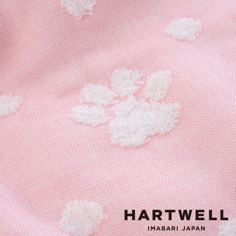 粉色今治純棉紗布浴巾，織有白色立體點點（肉球）圖案，材質輕柔透氣。