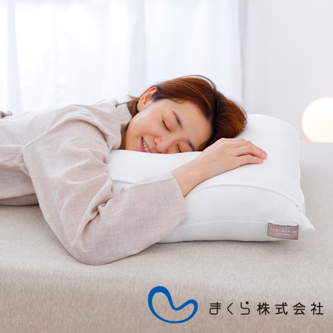 一名女子側臥於白色軟枕上，枕頭為白色，布料材質，表面平整。