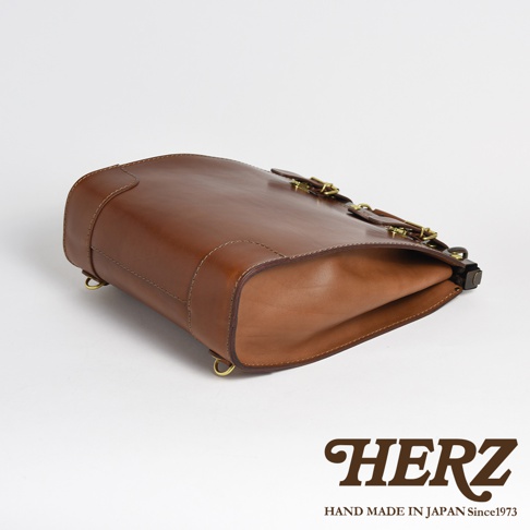 棕色皮革復古口金後背包，帶有金屬扣環和車線細節。