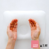 王樣嬰兒皇冠枕，白色網眼材質，中央有圓形凹槽，兩隻手放在枕頭兩側示範尺寸。