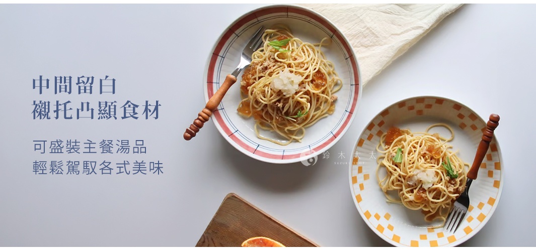 兩個陶瓷料理盤，其中一個有紅藍線條裝飾，另一個有橘色格子裝飾。盤中盛有義大利麵，並配有木柄叉子。