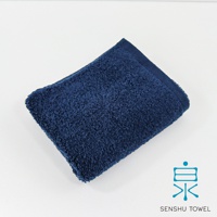 深藍色長纖毛巾，質地蓬鬆柔軟，邊緣有縫製的滾邊。