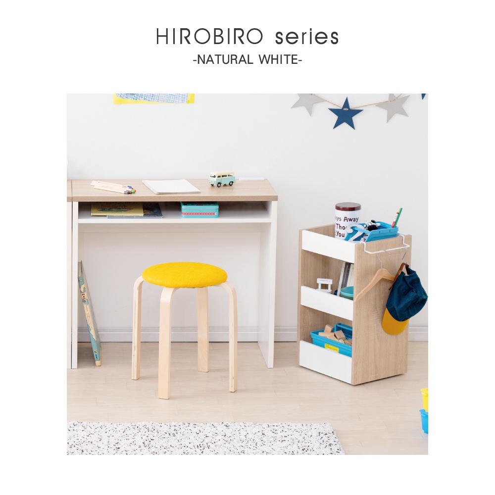 淺木紋與白色組合的木質可移動置物櫃，附有滾輪，櫃體有三個開放式層架，其中兩個層架內有藍色收納盒，右側掛有深藍色帽子與黃色帽簷。