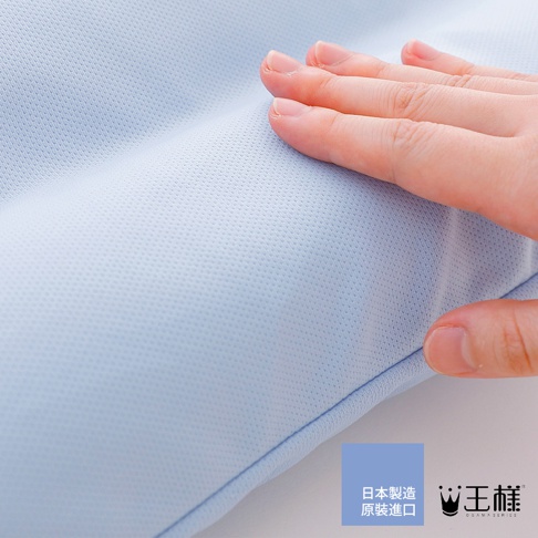 淺藍色網狀織物材質的枕頭，一隻手輕撫其表面，展現細緻的紋理。