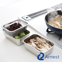 Arnest 不鏽鋼多功能濾網保鮮盒3件組，包含盛裝食材的濾網和不鏽鋼調理盤，旁邊是裝有香菇的不鏽鋼保鮮盒，後方有正在烹調的鍋子。