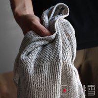 日本桃雪SEK抗菌防臭檜木鬆餅紋毛巾，手持灰白色紋理毛巾，局部特寫