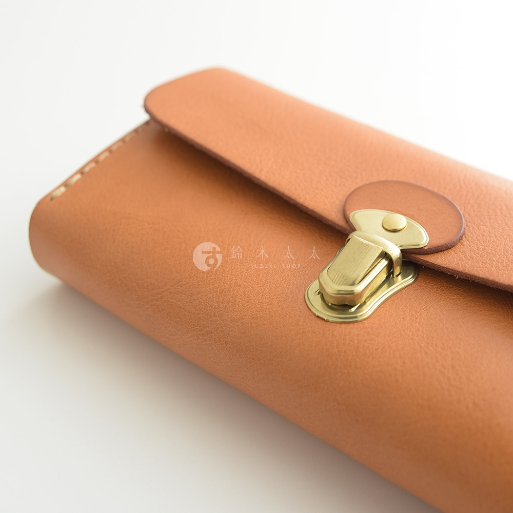 淺棕色皮革長夾，配有金色金屬扣環和旋鈕，展現職人手作的細緻工藝。