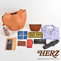 皮革球形肩掛托特包，搭配棕色化妝包、綠色長夾、黑色皮夾、紅色零錢包、手機、藍色印花手帕、白色紙巾、水瓶和黑色摺疊傘。