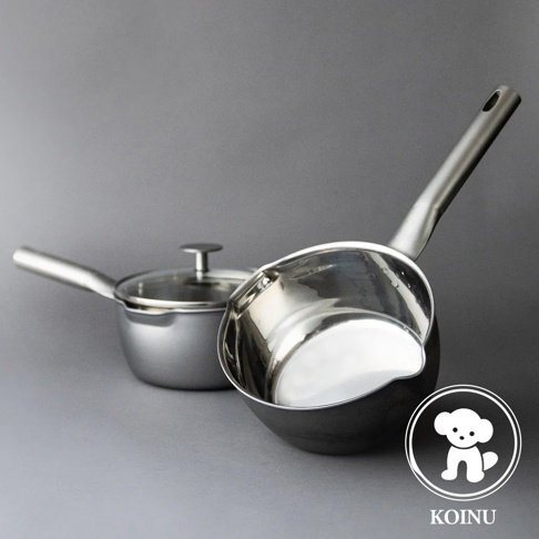 兩個銀色不鏽鋼雪平鍋，其中一個有玻璃鍋蓋，另一個是開放式設計，帶有長柄，鍋身呈現圓弧形，背景為灰色。