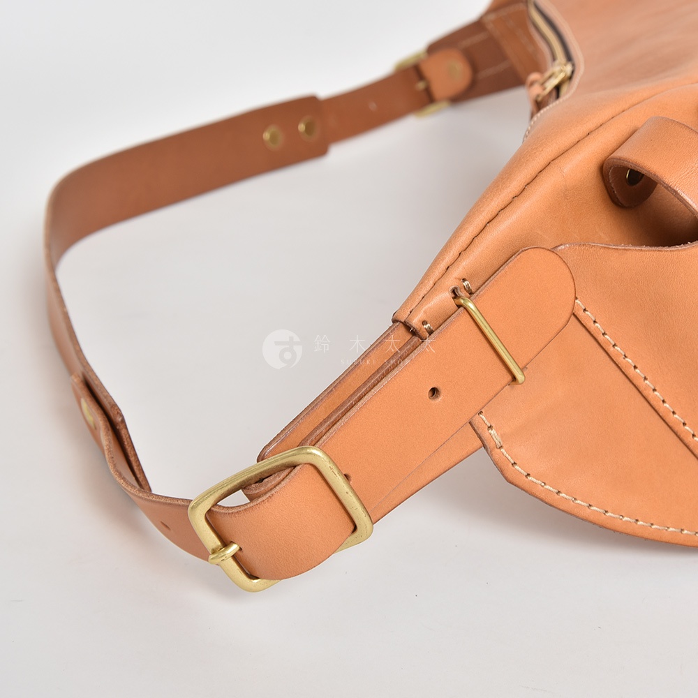 日本HERZ職人手作皮革大容量斜背包F-1細節，包含一條可調節的棕色皮革斜背帶，帶有黃銅色金屬扣環和調節器，近拍展現皮革紋理與縫線。