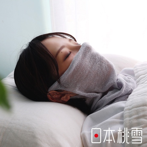 一位女子側睡在枕頭上，臉部及頸部覆蓋著一件灰色輕薄透氣的絲綢半面罩，右下方標示著日本桃雪品牌名稱。