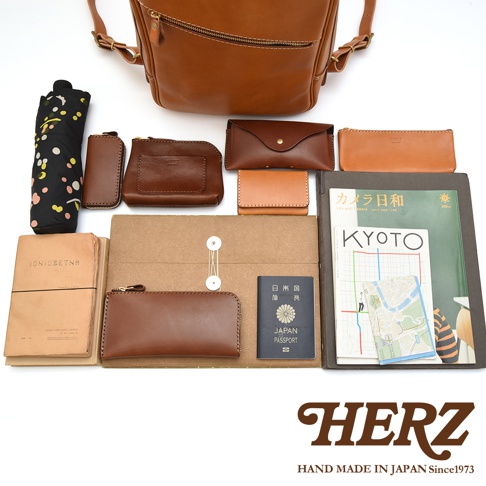 職人手作的皮革後背包，包含各種同色系的皮製配件：長夾、短夾、零錢包、鑰匙包。另有折疊傘、筆記本、護照和印有京都地圖的雜誌。