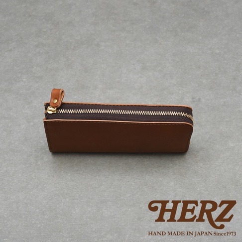 職人手作皮革Organ大容量拉鍊長夾，咖啡色皮革，設有金色拉鍊與皮革拉環，品牌HERZ字樣及HAND MADE IN JAPAN Since1973標示。