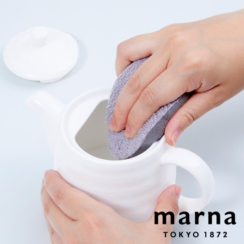 marna tokyo 1872 品牌的手正在使用灰色海綿清潔白色茶壺內部。