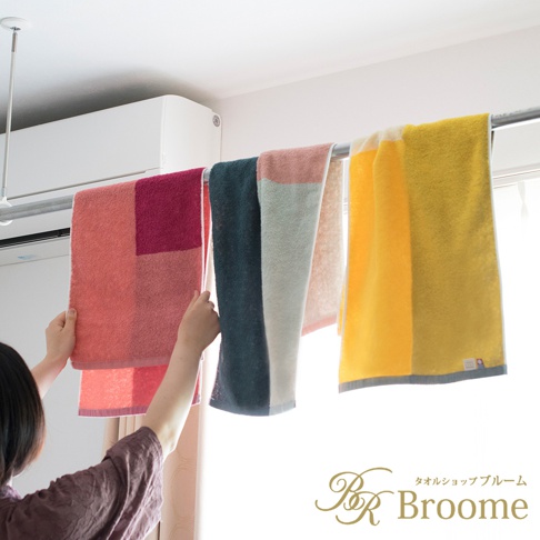 今治KAKUTERU純棉毛巾，展示四種色彩組合：粉紅與深紅撞色、藍綠色、淺灰與粉色塊拼接、以及亮黃色。毛巾材質為純棉，色彩鮮豔。