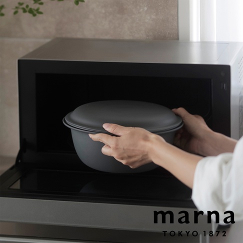 marna Tokyo 1872 品牌標誌旁，一雙手將灰色耐熱可微波洗濾盆托盤放入微波爐內。