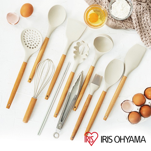 一套淺米色廚房用具，包含漏勺、湯勺、麵勺、鍋鏟、打蛋器、夾子、油刷及筷子，皆配有木質手柄。