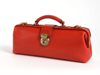 紅色皮革橫長形單肩包，配有黃銅色旋轉鎖扣和提把，包身側面有金屬D型環。