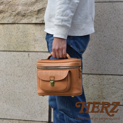 職人手作皮革軟皮相機包 N-6，採用天然棕色皮革製成，設有頂部提把、拉鍊主隔層及前方翻蓋小口袋，搭配金色金屬鎖扣及拉鍊，風格簡約實用。