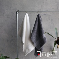 兩條今治匹馬棉浴巾，一條為白色，另一條為灰色，皆懸掛於金屬毛巾架上，背景為水泥牆面。