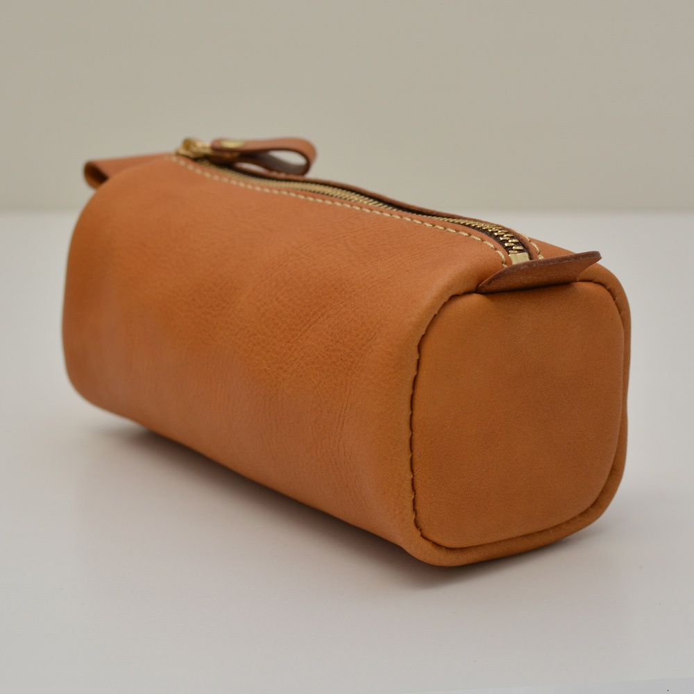 職人手作皮革多用途收納筆袋，採用棕褐色皮革製成，圓筒形設計，配有金色拉鍊和皮革拉頭，車線清晰，質感良好。