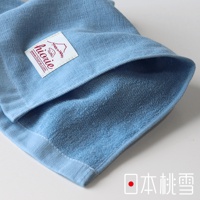淺藍色紗布方巾，質地柔軟，一面為細緻的紗布紋理，另一面為毛圈織法，帶有紅色標籤，印有品牌名稱與「Made in Japan」。