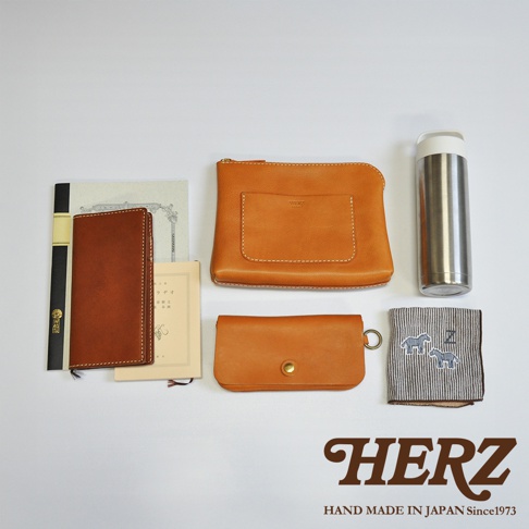 皮革長夾、皮革筆記本套、皮革零錢包、金屬保溫瓶、條紋手帕，皆為棕色或銀色調。