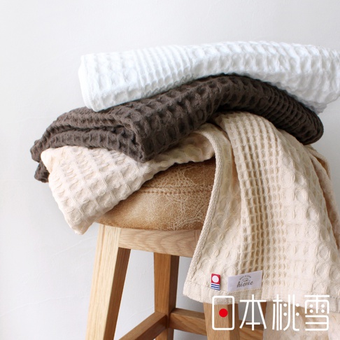 堆疊的今治鬆餅方巾，呈現白色、咖啡色和米白色，皆為柔軟的棉質材質，擁有獨特的格子紋理。