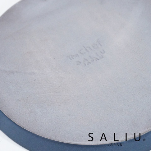 The Chef Saliu 品牌淺灰色陶製圓形烤盤，底部有 Saliu Japan 商標。